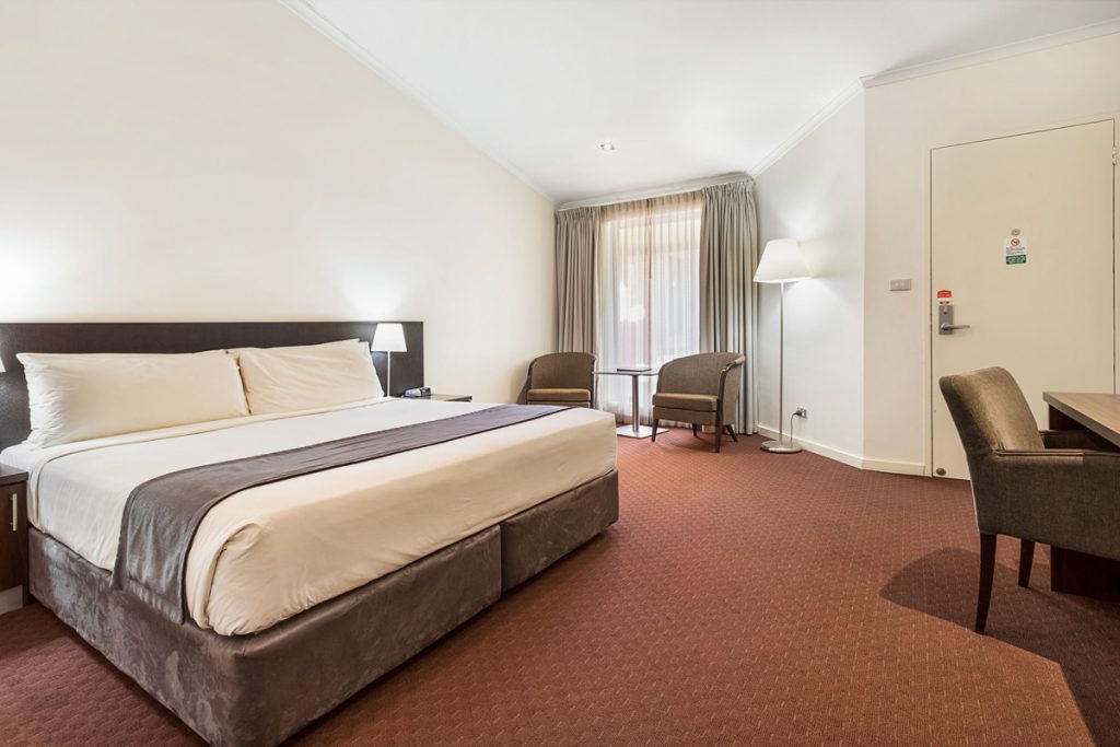 The Deluxe Palm Room includes a queen-size bed, work desk and chairs