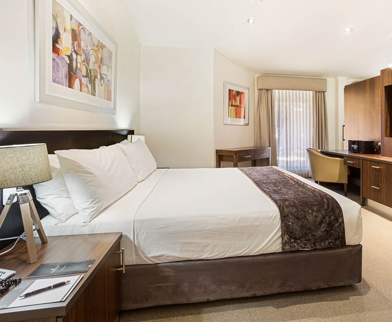 The Presidential Suite at the Karratha International Hotel features modern furnishings, a king-size bed, and a spacious living area