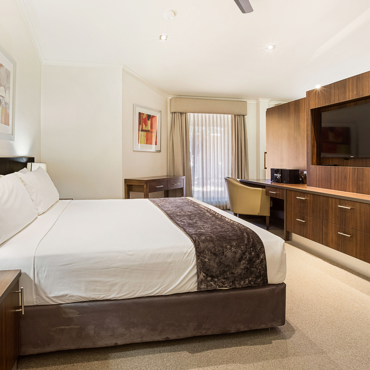 The Presidential Suite at the Karratha International Hotel features modern furnishings, a king-size bed, and a spacious living area