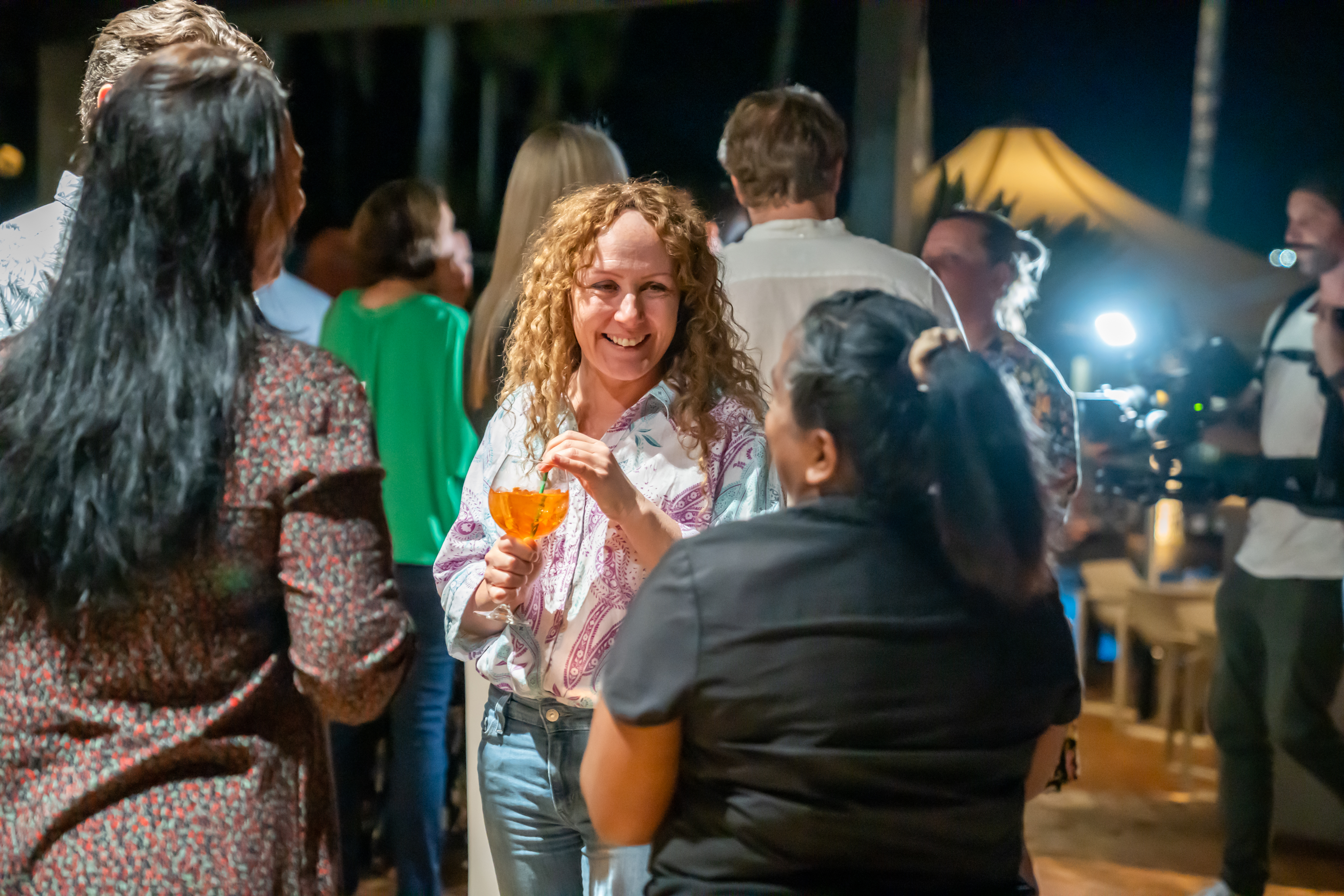 Three function guests smile while enjoying drinks at Luce Bar e Cibo